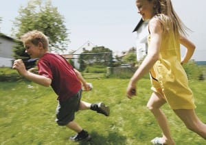 Zwei Kinder rennen auf Wiese