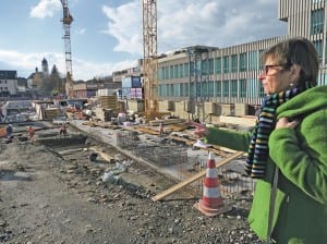 Irene Sidler, Leiterin der Gemeindebibliothek, zeigt auf der aktuellen Baustelle, wo im Frühling 2015 die Bibliothek neu zu stehen kommen wird. Foto züsu