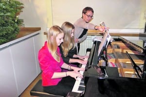 Sarah Hirschi und Nina Cavietzel vierhändig am Klavier, zusammen mit Estelle Lustenberger.
