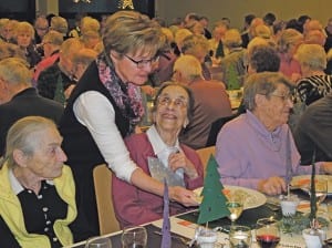 Maria End serviert den strahlenden Seniorinnen und Senioren das festliche Essen.