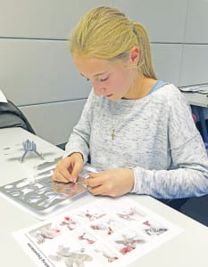 Céline Stirnimann setzt nach Anleitung einen Doppeldecker aus Metall zusammen. Den Modell-Flieger durften die Schülerinnen und Schüler als Andenken mit nach Hause nehmen.