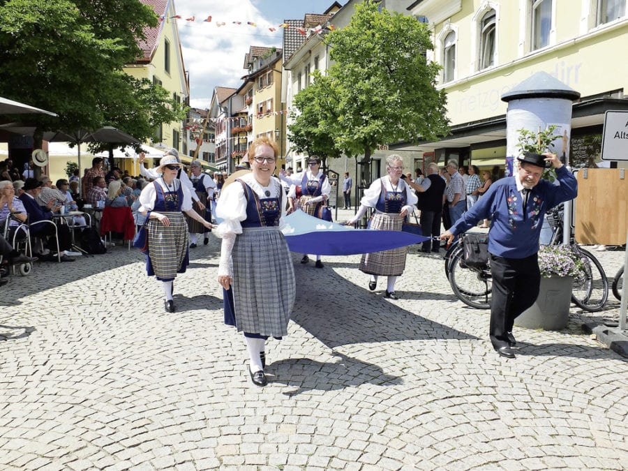 Die Trachtenleute tragen den Rotsee durch die Strassen von Tiengen.