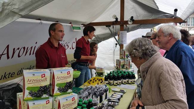 Marktstand mit Aroniasaft und Aronia Produkten Marktstand mit Aroniasaft und Aronia Produkten
